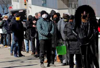 FILE PHOTO: People wait for COVID-19 vaccinations at mass vaccination site in Manhattan in New York