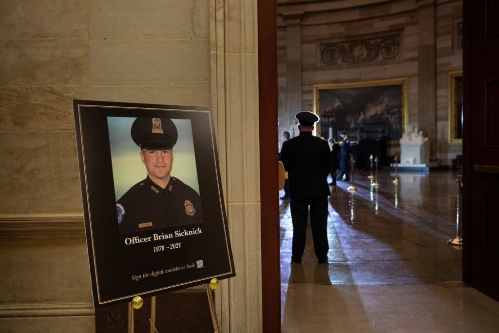 A picture of of Capitol Police officer Brian Sicknick is seen as people wait for his remains to arrive to lay in honor in the Rotunda of the U.S. Capitol building in Washington