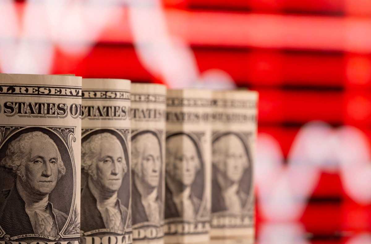 FILE PHOTO: FILE PHOTO: U.S. one dollar banknotes are seen in front of displayed stock graph