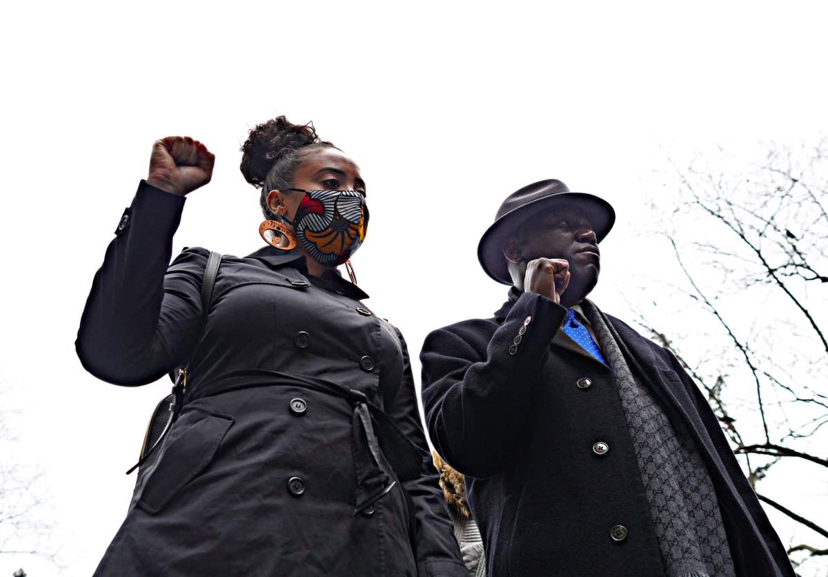 Katty Rodriguez and Ben Crump raise their fists up for justice
