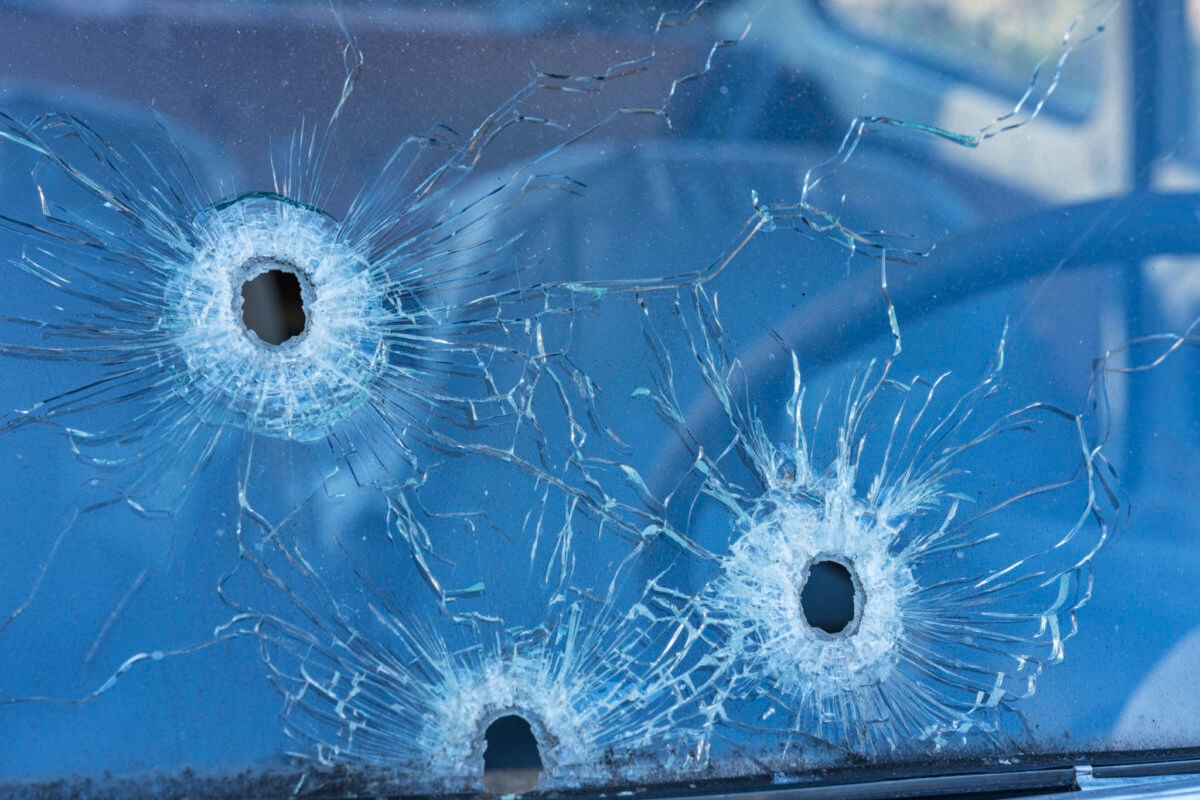 Bullet holes in the front safety glass of car.