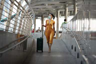 Woman walking with luggage at railroad station