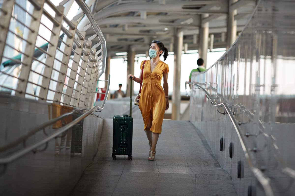 Woman walking with luggage at railroad station