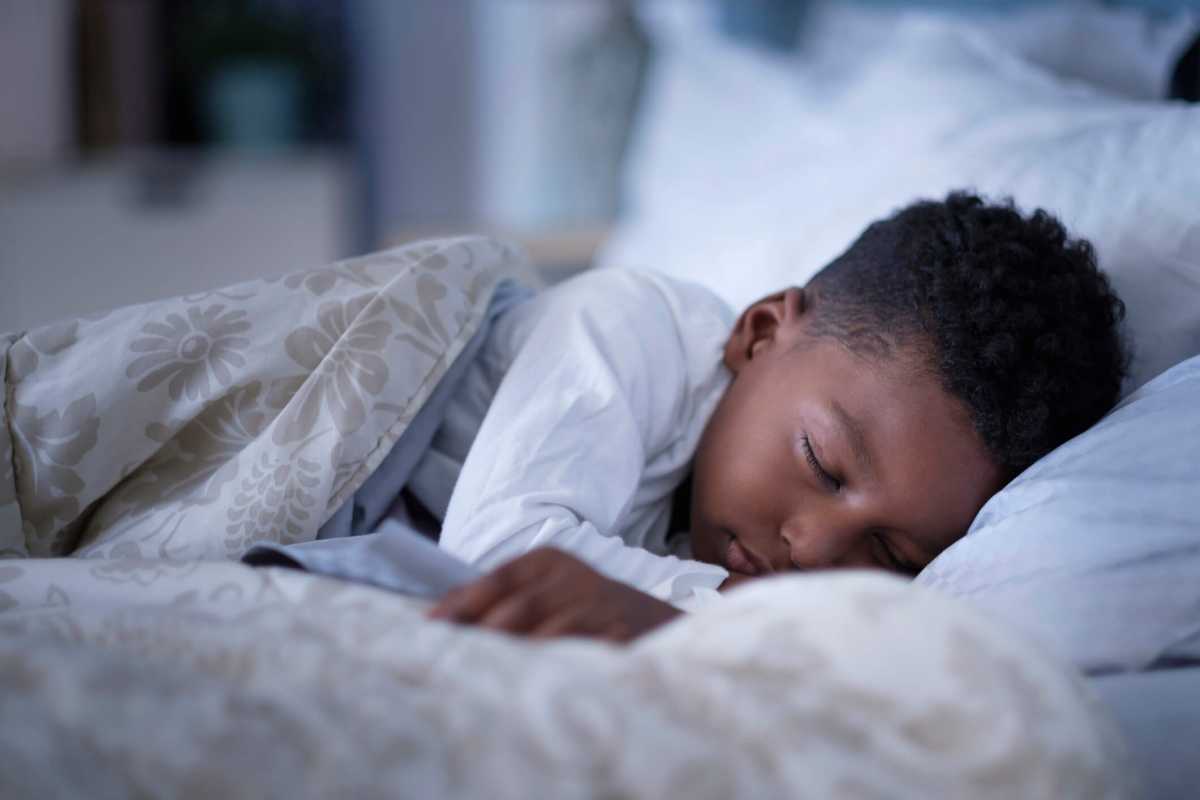 Boy (6-7) sleeping in bed