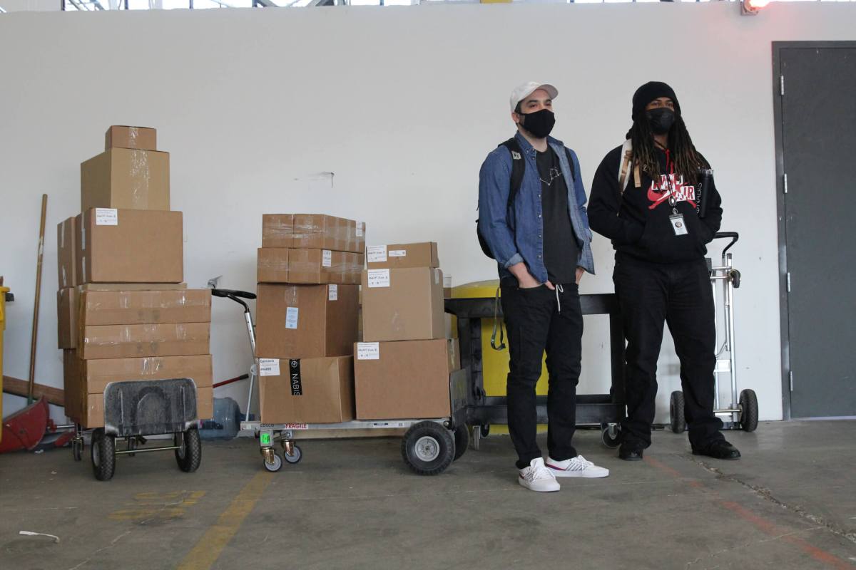 Nabis delivery specialists Daniel Avina and Tyler Hattix wait next to a shipment of cannabis products at the Nabis warehouse in Oakland,