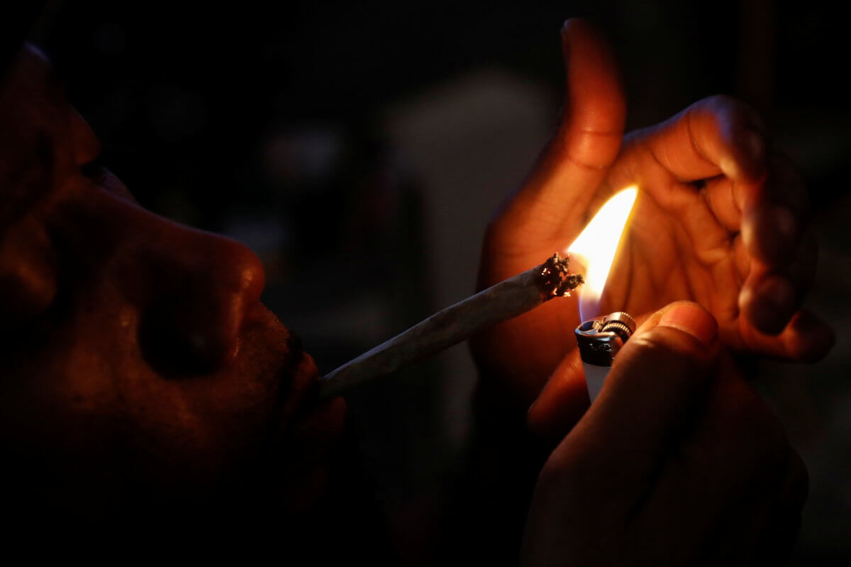 A man smokes a hybrid strain joint of cannabis at his home in New York