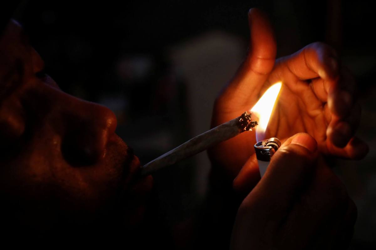 A man smokes a hybrid strain joint of cannabis at his home in New York