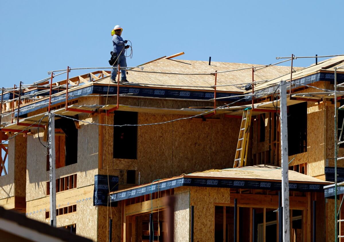 FILE PHOTO: A worker walks on the roof of a new home under construction in Carlsbad