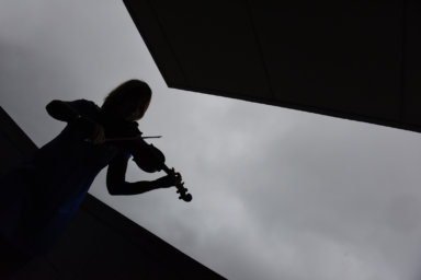 Eszter Balint playing violin in the misty fog of memory.