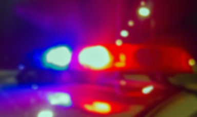 Lights of police car in night time, crime scene. Night patrolling the city, lights flashing. Abstract blurry image.