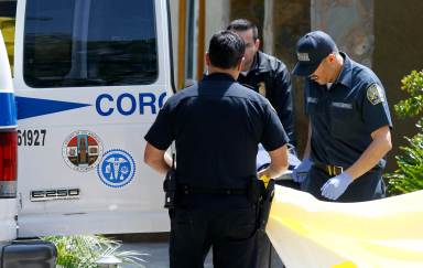 FILE PHOTO:Los Angeles County coroner and forensic specialists remove a body from a home on Ramsey Way where four people were found dead, in Pomona, California