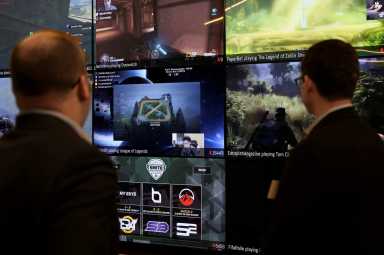 FILE PHOTO: Men look at a wall of real-time video game play in the lobby of Twitch Interactive Inc, a social video platform and gaming community owned by Amazon, in San Francisco, California