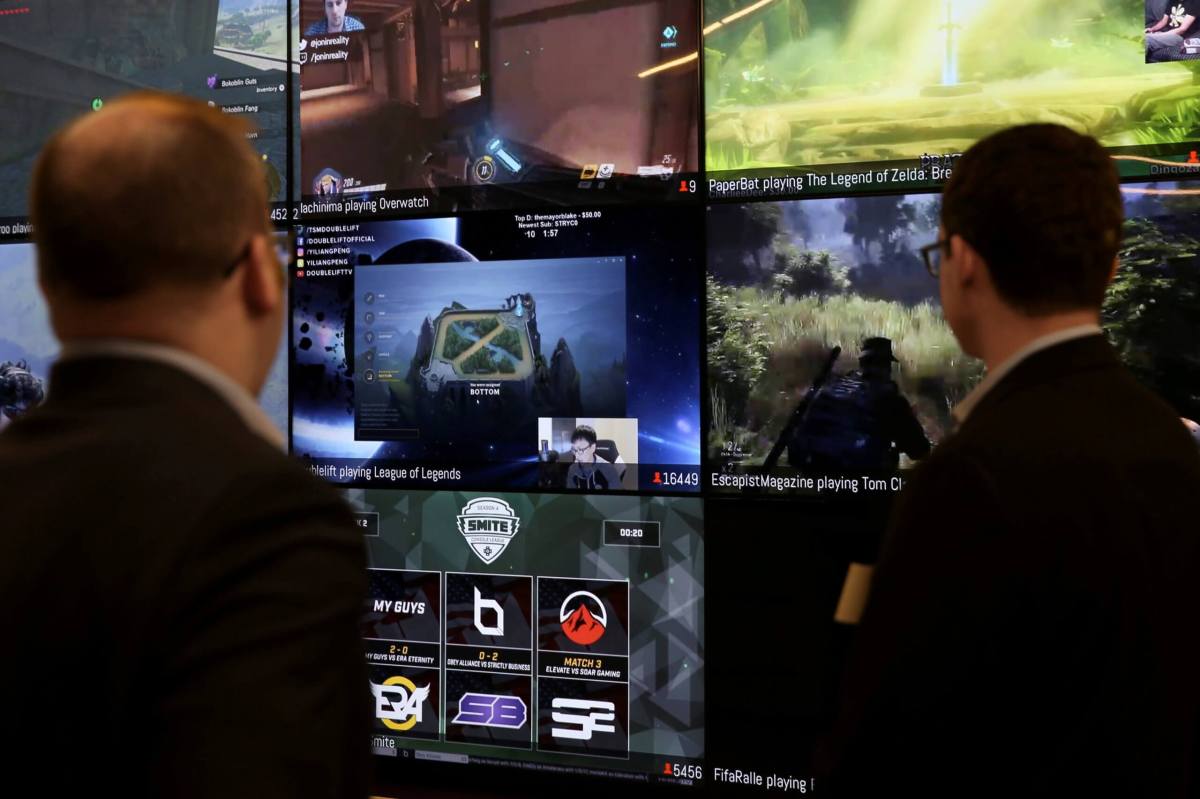 FILE PHOTO: Men look at a wall of real-time video game play in the lobby of Twitch Interactive Inc, a social video platform and gaming community owned by Amazon, in San Francisco, California