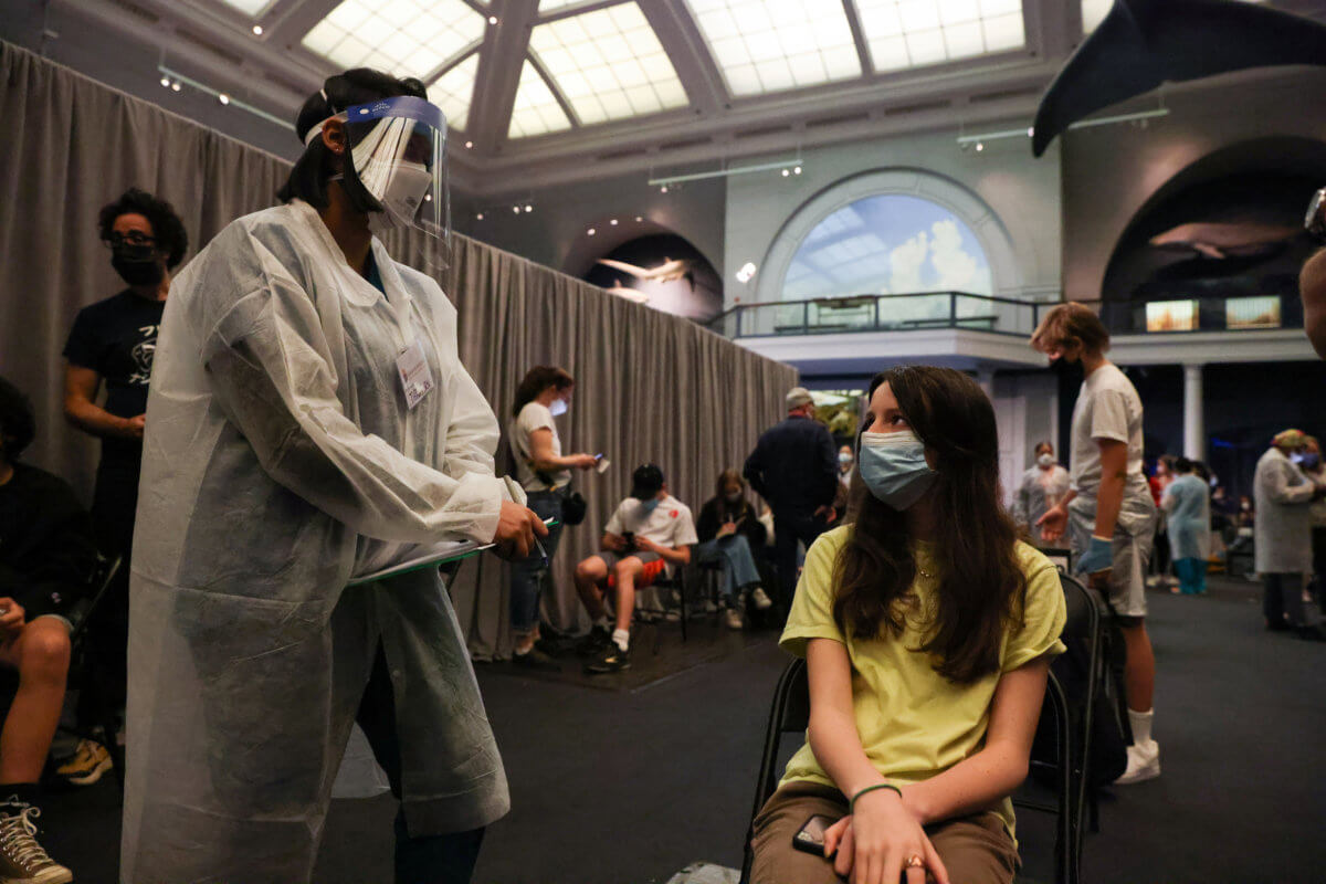 Jane Hassebroek speaks with a healthcare professional after receiving the COVID-19 vaccine at the American Museum of Natural History in New York