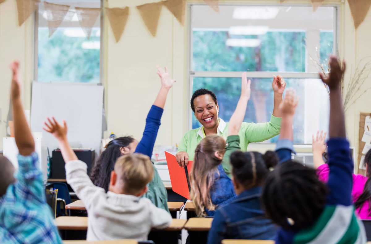 African-American teacher reading to school children