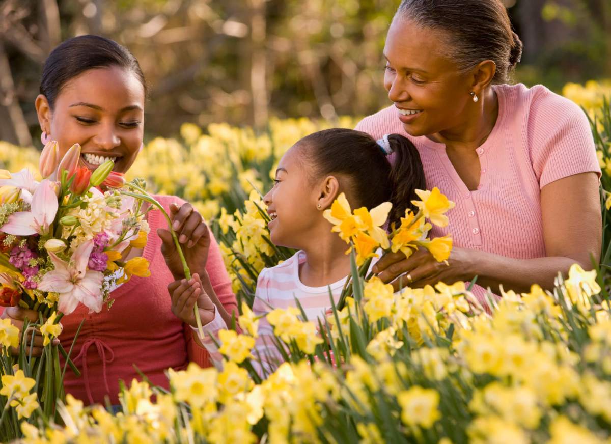 African grandmother, mother and daughter picking flowers