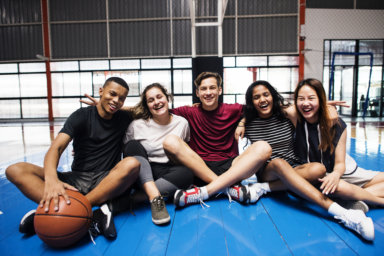 Group of young teenager friends on a basketball court relaxing portrait