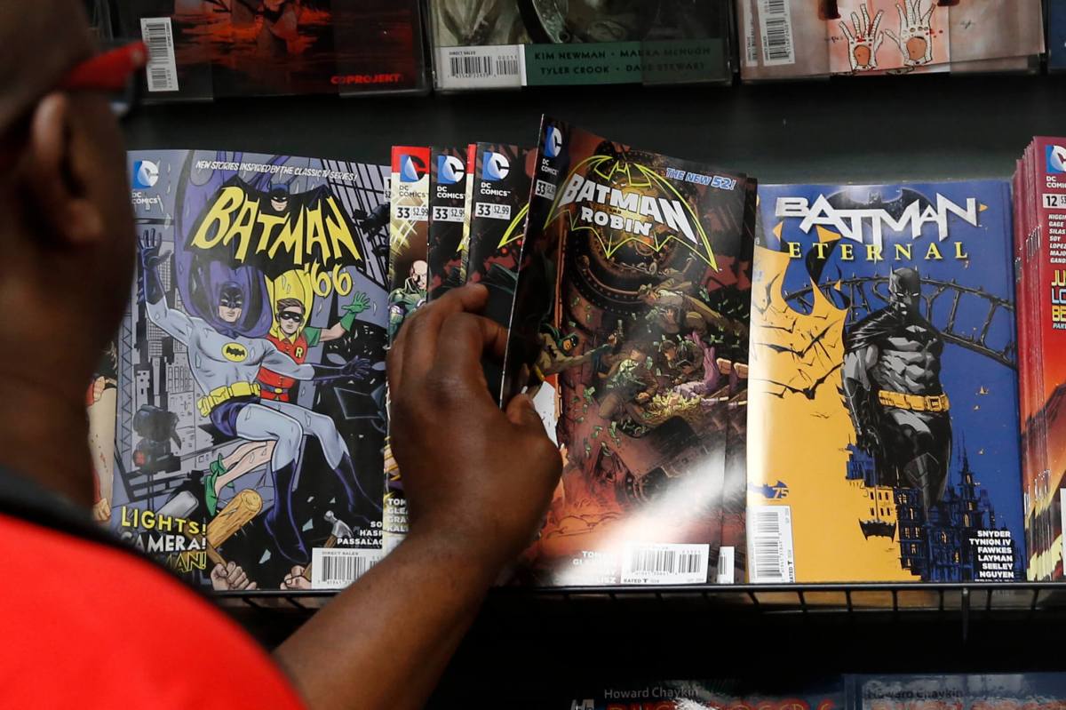 A man reaches for a Batman comic book during Batman Day at the Midtown Comics store in New York