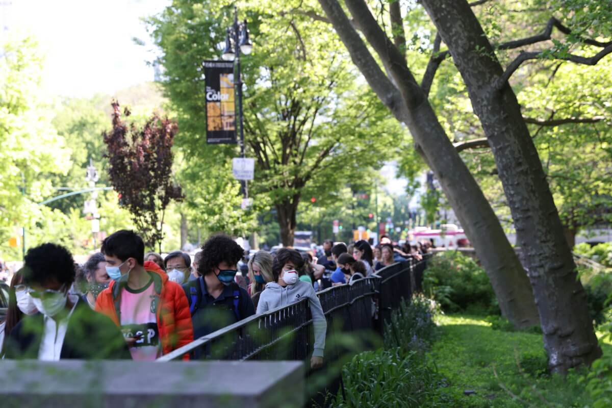 People ages 12 and older line up for COVID-19 vaccine appointments outside the American Museum of Natural History in New York