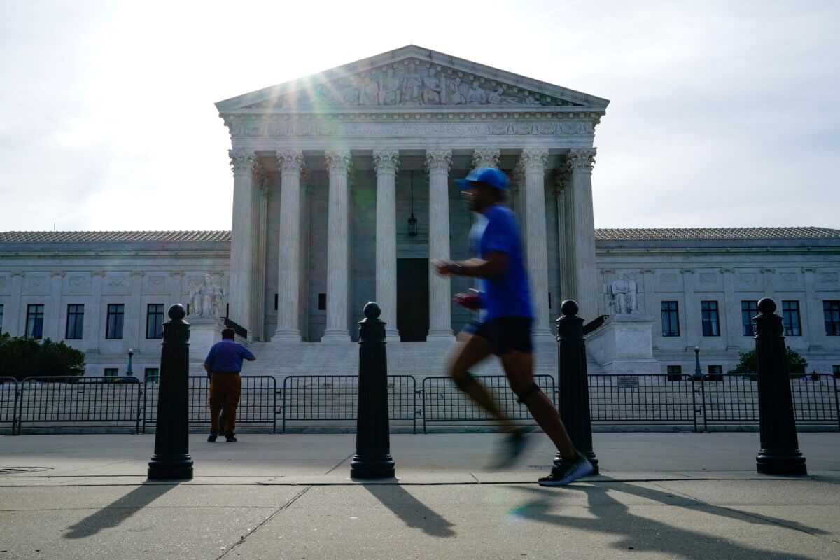 FILE PHOTO: People walk past the U.S. Supreme Court the day the court is set to release orders and opinions in Washington