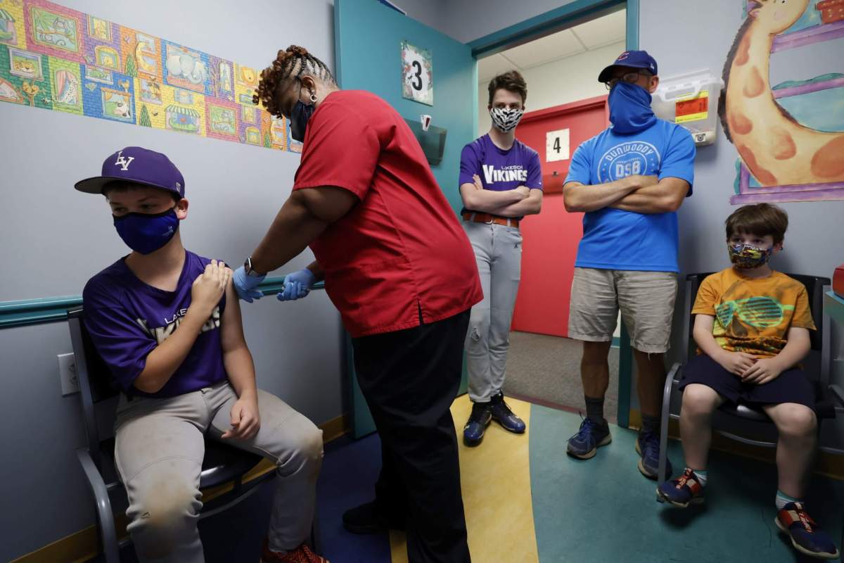 FILE PHOTO: Family members look on as Jack Frilingos, 12, is inoculated with Pfizer’s vaccine against coronavirus disease (COVID-19) after Georgia authorized the vaccine for ages over 12 years, at Dekalb Pediatric Center in Decatur