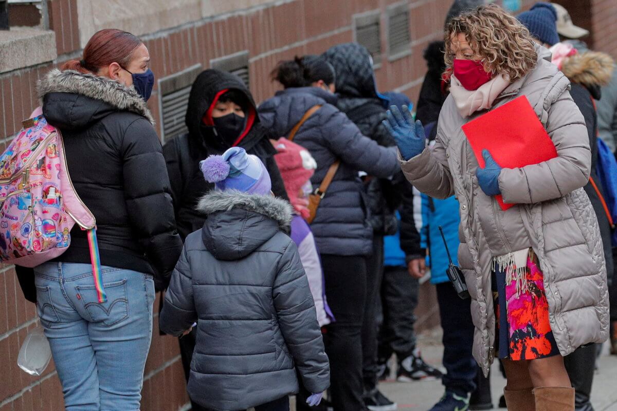 FILE PHOTO: A principal greets students as they return to New York City’s public schools for in-person learning at P.S. 506 in Brooklyn, New York