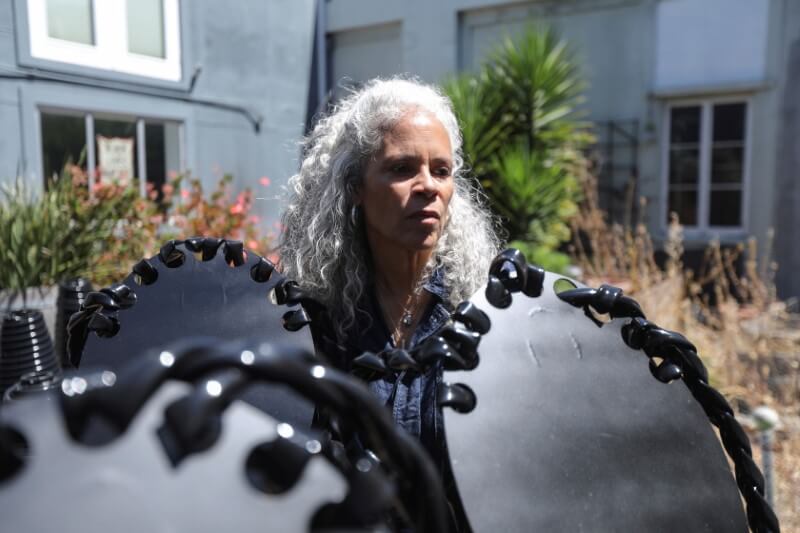 Sculptor Dana King stands among “ancestor” statues she created for an upcoming exhibit called “Monumental Reckoning” while at her studio in Oakland