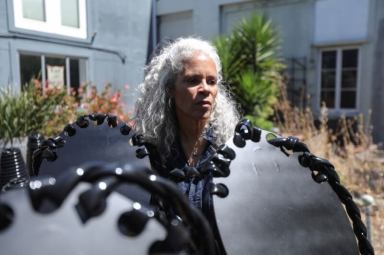 Sculptor Dana King stands among “ancestor” statues she created for an upcoming exhibit called “Monumental Reckoning” while at her studio in Oakland