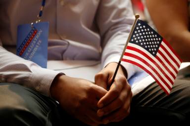 FILE PHOTO: A new citizen holds a U.S. flag at the U.S. Citizenship and Immigration Services (USCIS) naturalization ceremony at the New York Public Library in Manhattan