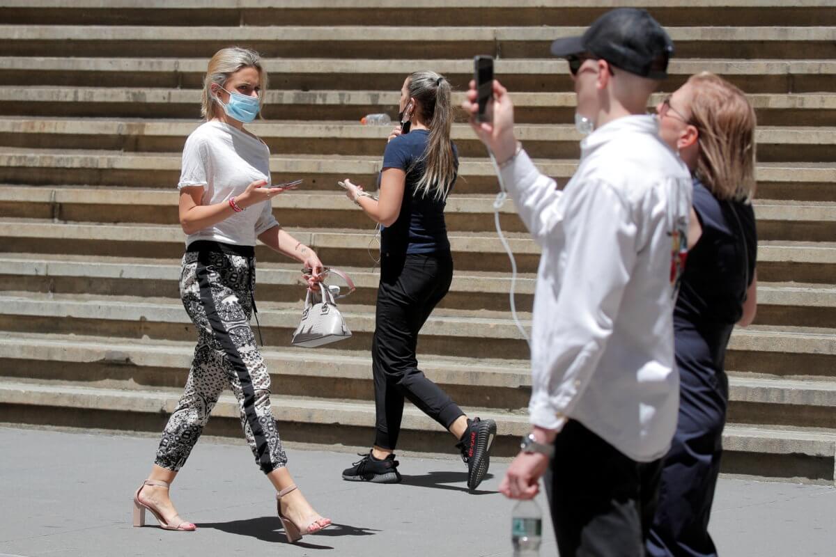 People enjoy a sunny day on Wall Street outside of the NYSE  in New York