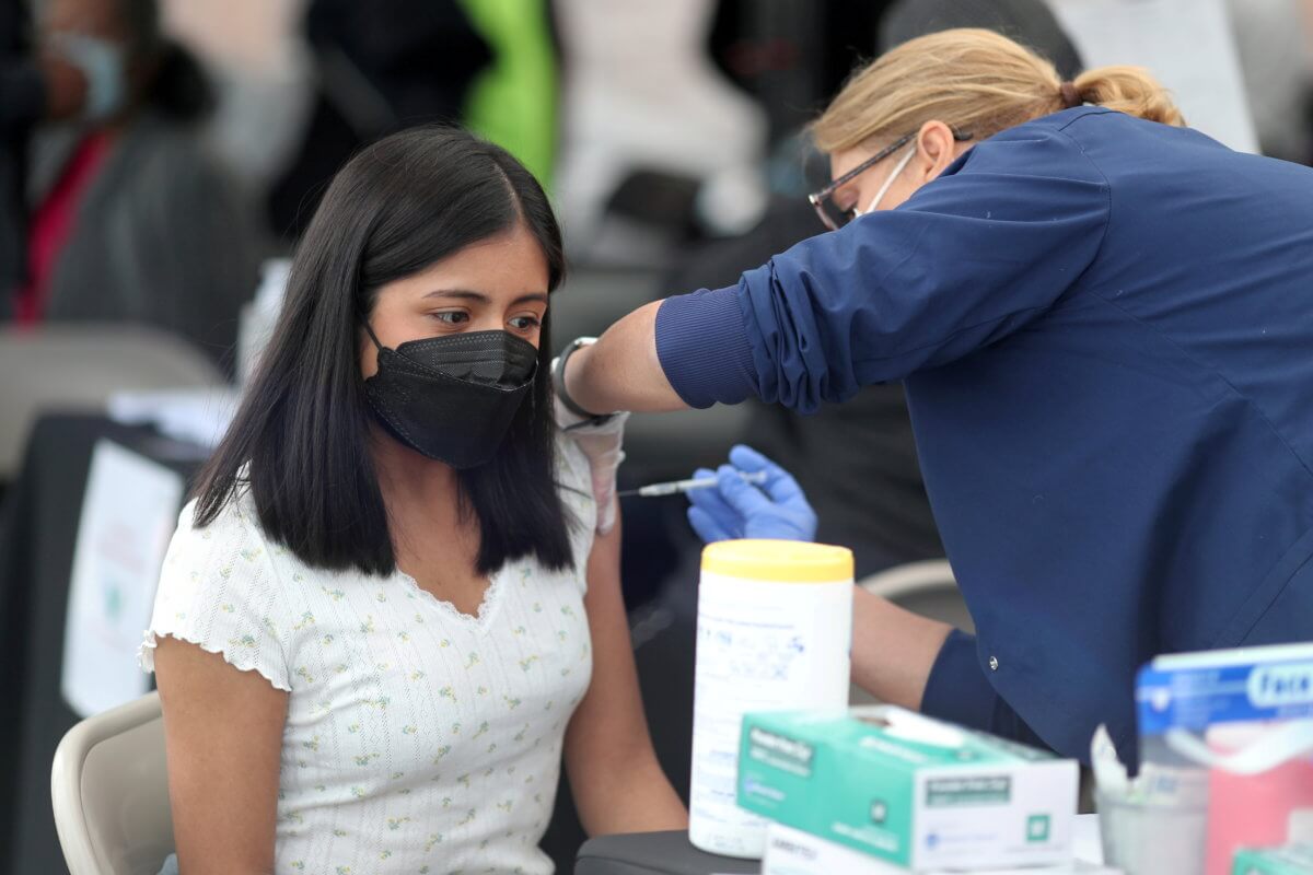FILE PHOTO: A woman receives a coronavirus disease (COVID-19) vaccination, at Jordan Downs in Los Angeles