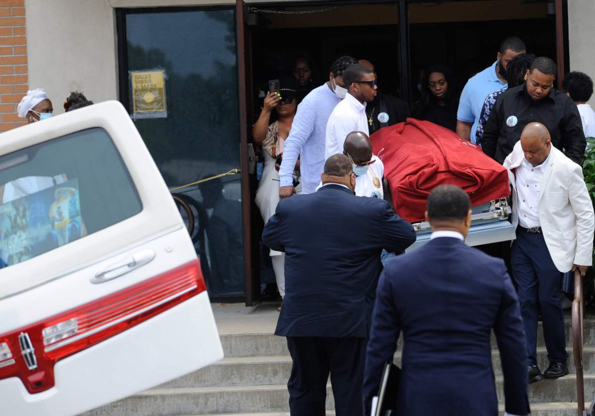 The casket of Justin Wallace is brought out of the church.