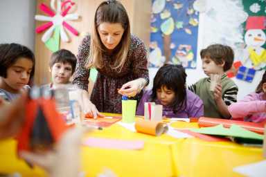 Special education teacher assisting elementary students in art class