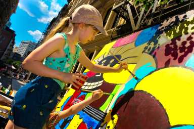 Adding more color to the plywood mural. (Two hands are better than one.)