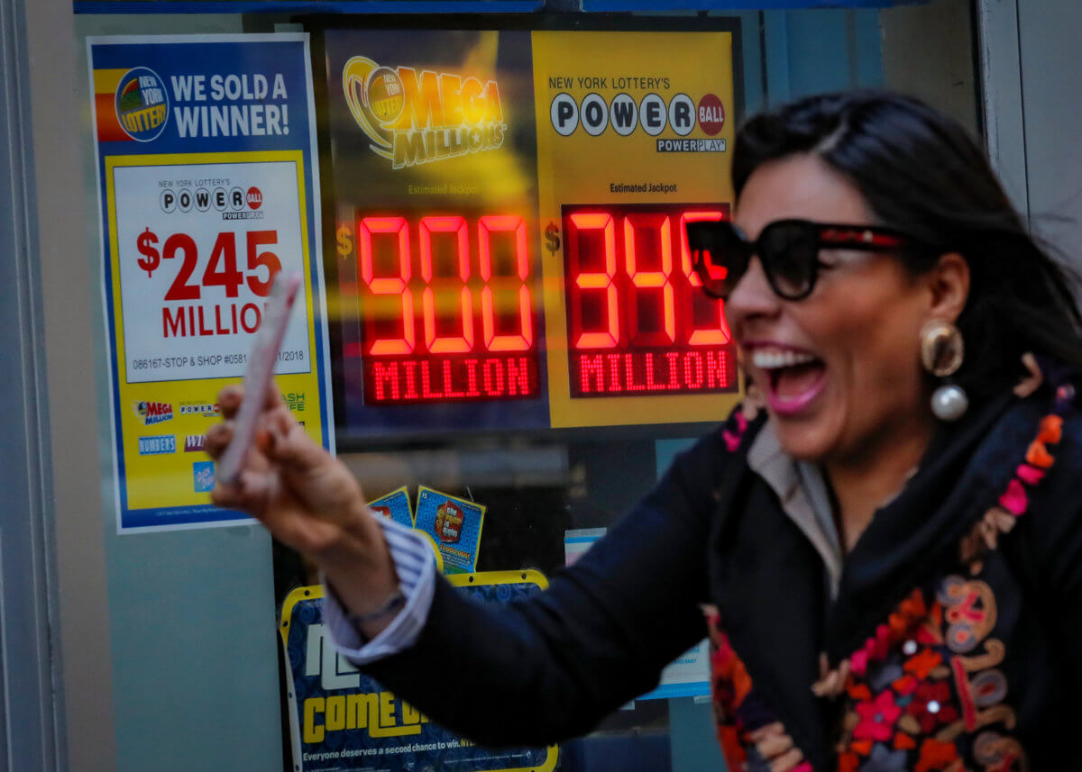 Signs display the jackpots for Friday’s Mega Millions and Wednesday’s Powerball lottery drawings in New York