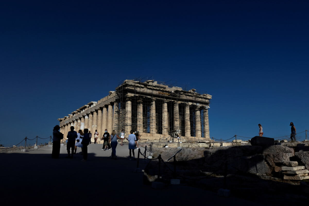 FILE PHOTO: People visit the Parthenon temple atop the Acropolis hill in Athens