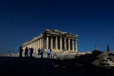 FILE PHOTO: People visit the Parthenon temple atop the Acropolis hill in Athens