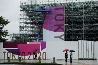 Construction workers are seen next to a scaffoldings for the spectator seats at Aomi Urban Sports Park in Tokyo