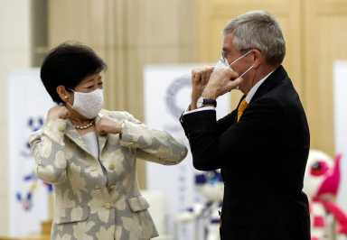Tokyo Governor Yuriko Koike and Thomas Bach, President of the International Olympic Committee (IOC), bump elbows at the start of their talks at Tokyo Metropolitan Government Office Building in Tokyo
