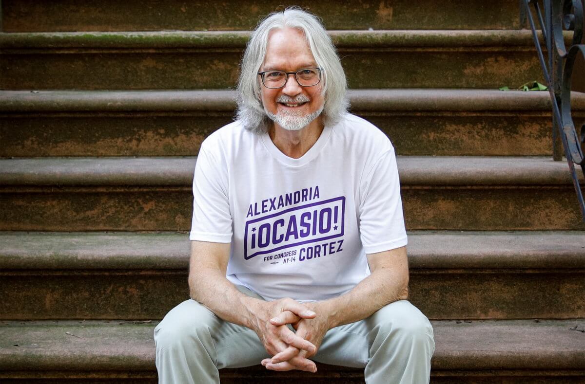 Peter Hogness poses wearing his Alexandria Ocasio-Cortez branded T-shirt in the Park Slope area of Brooklyn, New York
