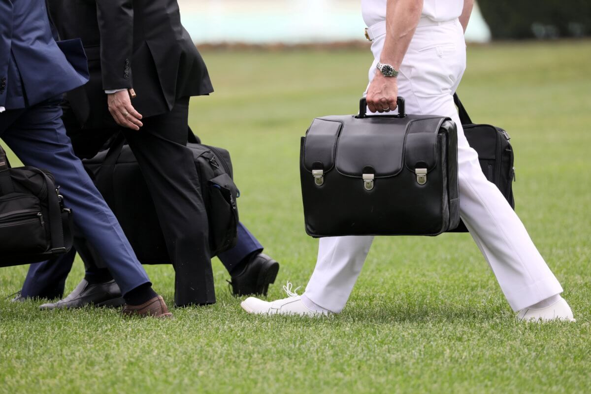 FILE PHOTO: A military aide carries the so-called nuclear football as he walks to board the Marine One helicopter with U.S. President Trump for travel from the White House in Washington