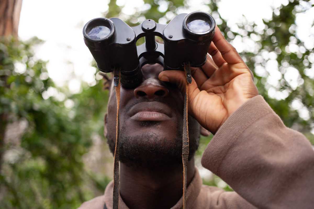 A handsome man looking at something intently through inoculars