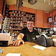 Owner of Organic Grill in Village behind counter