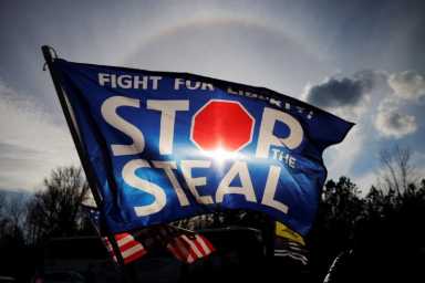 A “Stop the Steal” flag flies outside a campaign rally with President Trump in Dalton