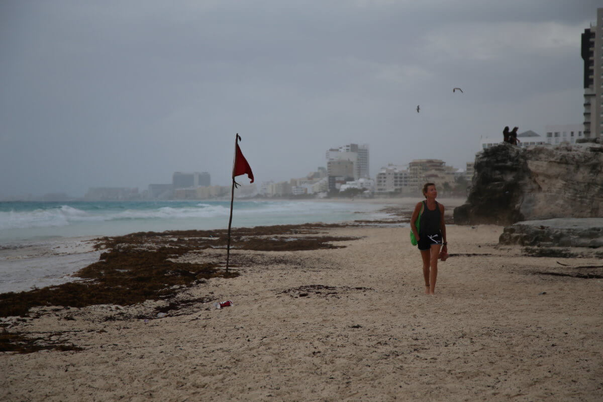 A tourist walks on a beach as Hurricane Grace approaches, in Cancun