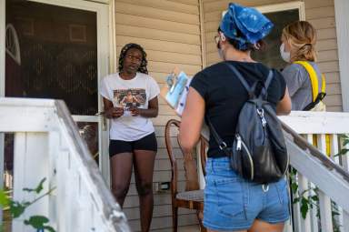 Karla Conrad and Denver Foote, canvassers with Iowa Citizens for Community Improvement, knock on doors to register people to vote in upcoming local elections in Des Moines, Iowa