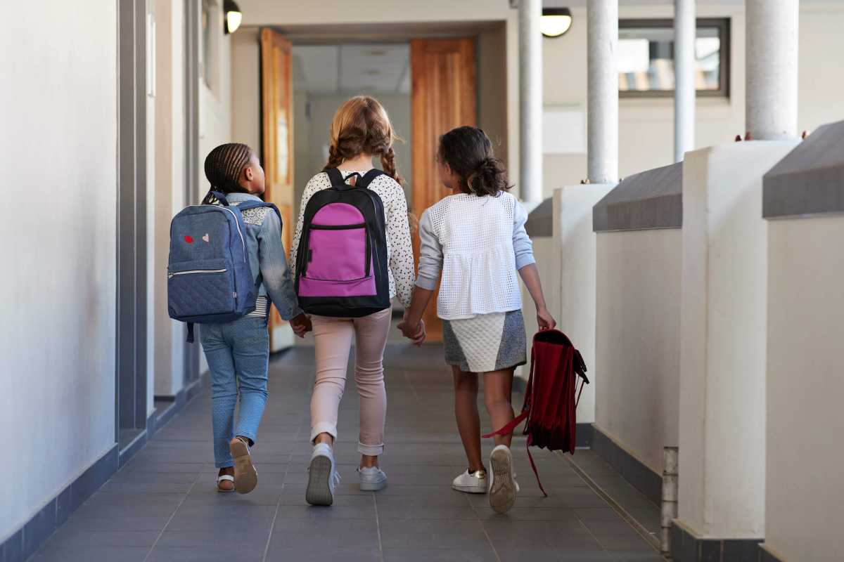 Girlfriends walking hand in hand on school isle