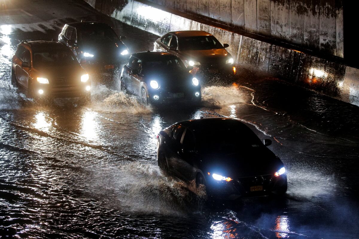 Cars navigate a flooded highway in Queens, New York