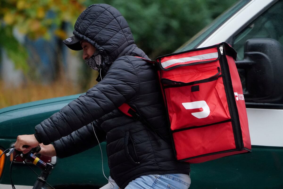 FILE PHOTO: A delivery person for Doordash rides his bike in the rain during the coronavirus disease (COVID-19) pandemic in the Manhattan borough of New York City