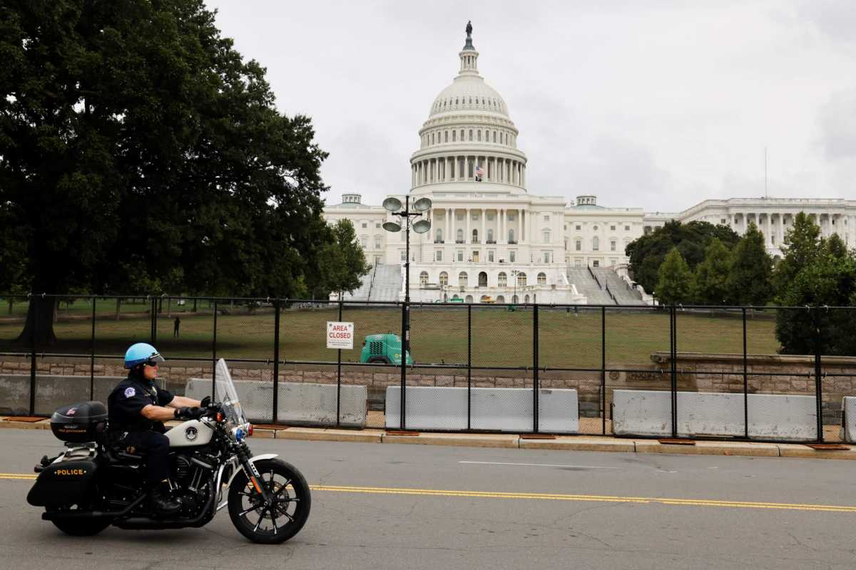 A U.S. Capitol Police officer patrols the unscalable fence erected around the Capitol ahead of an expected rally Saturday in support of the Jan. 6 defendants in Washington